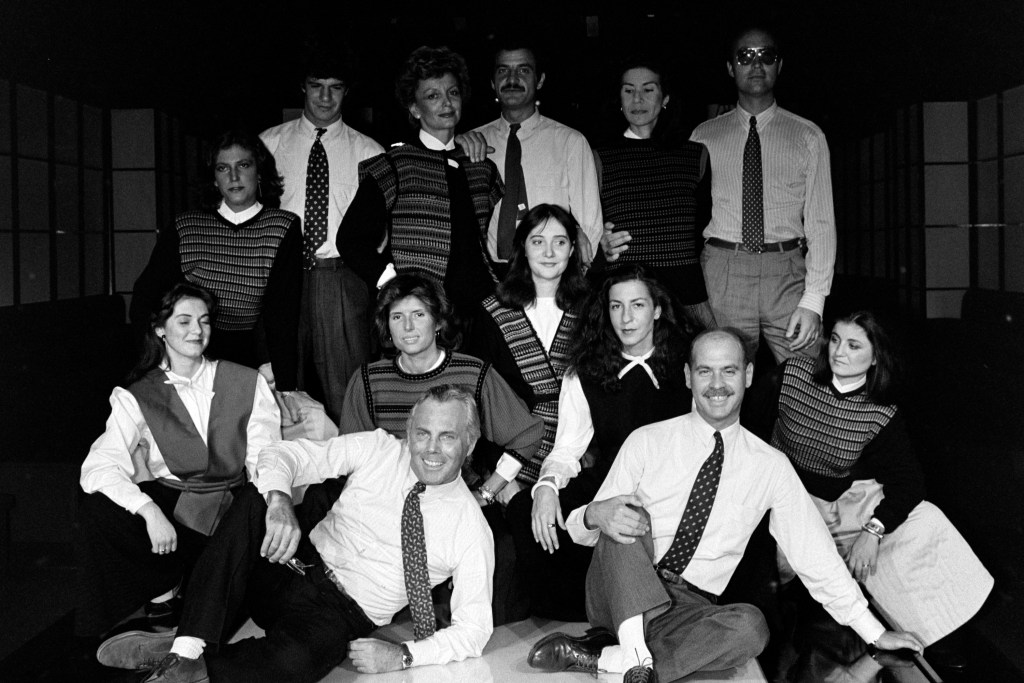 Designer Giorgio Armani, Silvana Armani, Sergio Galeotti, and guests pose for group photo. Some of the staff members wear selections from Armani's ready to wear collection.